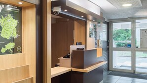 Una zona de recepción con un mostrador de madera, una cámara de seguridad y un mapa en la pared.