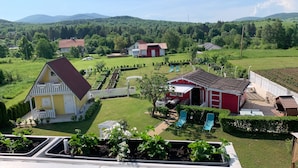 Un paysage rural avec des maisons, un jardin et une vue sur les montagnes.