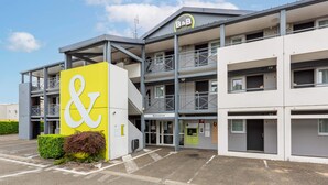 A modern hotel with a prominent yellow and white sign, multiple balconies, and a welcoming entrance. - B&B HOTEL CHARTRES Le Forum (1) (Le Coudray)