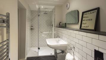 A modern bathroom with a shower, a sink, and a mirror.