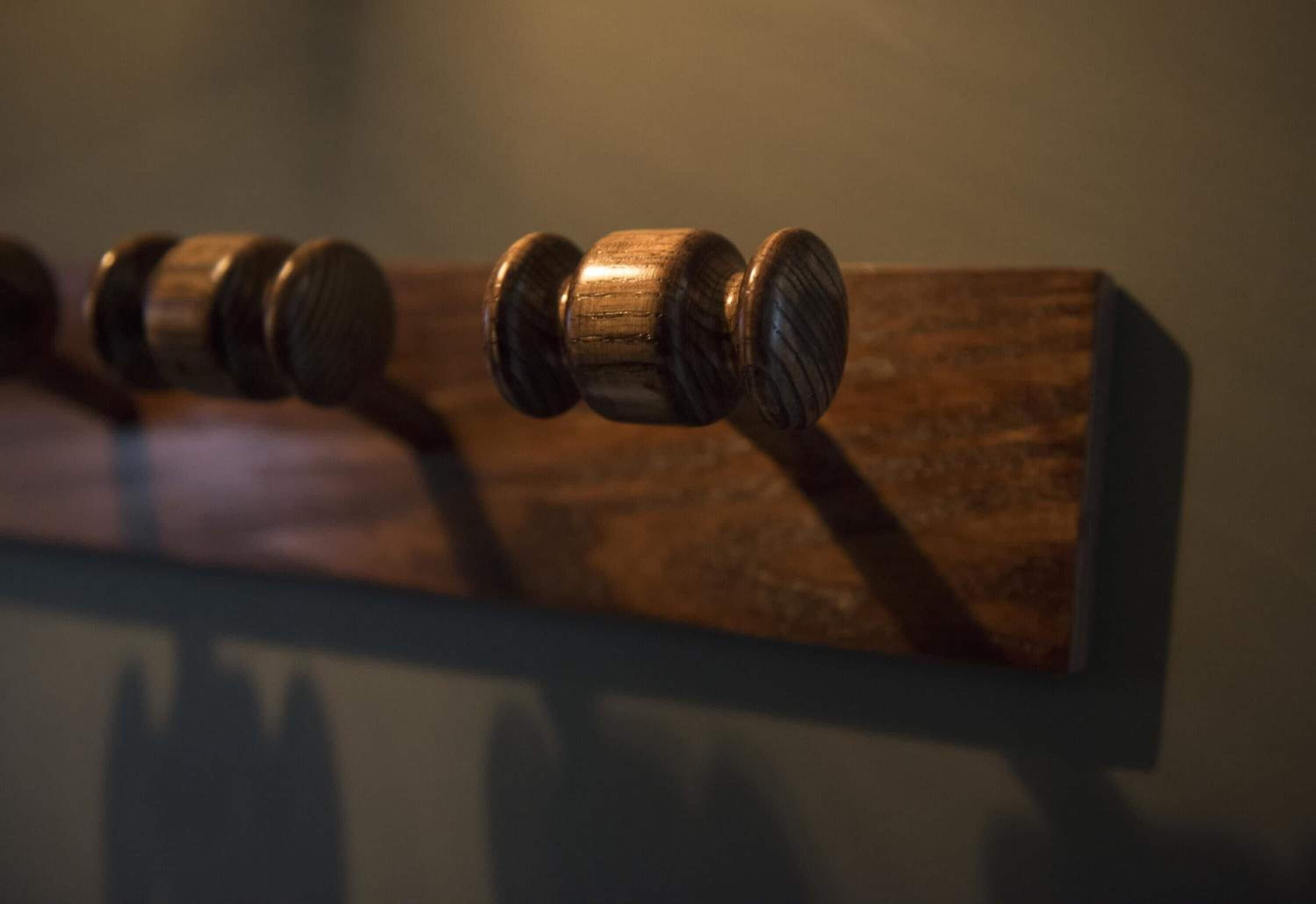 Een close-up van een houten object met een handgreep, mogelijk een deurklink of een meubelonderdeel.