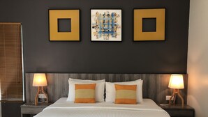 A hotel room with a large bed, two bedside lamps, a headboard, and three framed artworks on the wall. - Fuuka Villa (Langkawi)