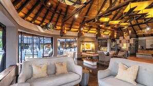 A spacious interior with two light grey sofas, a wooden coffee table, and a thatched ceiling. - Chobe Water Villas (Kasika)