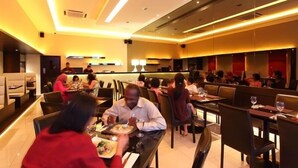 Un restaurante con varias mesas y sillas, un diseño de interiores moderno y una iluminación cálida.