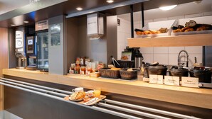 Un comptoir pour le petit-déjeuner avec divers aliments et une machine à café.