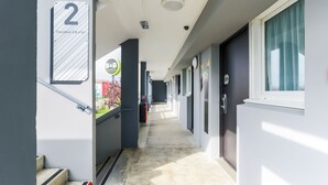 Un pasillo de hotel con una escalera que lleva a la habitación 2, un letrero de B&B y una cámara de seguridad.