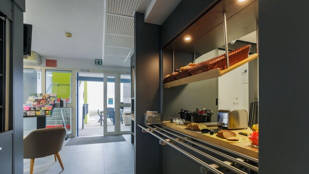 Una cocina moderna con horno integrado, tostadora y un escurreplatos para pan.