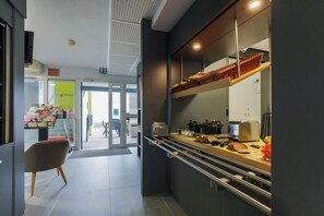 Una cocina moderna con horno integrado, tostadora y un escurreplatos para pan.