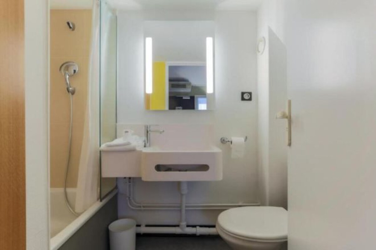 Un baño pequeño y moderno con inodoro, lavabo y ducha.