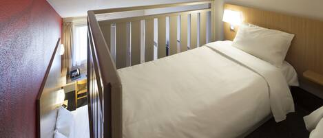 A hotel room with a bed, a nightstand, a lamp, and a view of a balcony.