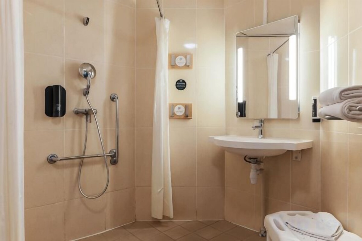 Un baño con ducha, lavamanos e inodoro.