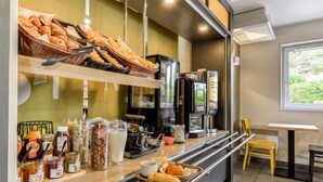 A breakfast counter with pastries, coffee machines, and various condiments. - B&B HOTEL Montpellier (1) (Saint-Jean-de-Vedas)