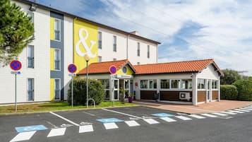 Hotel entrance with covered area and designated parking spaces.