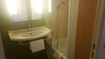 A bathroom with a sink, mirror, and shower.