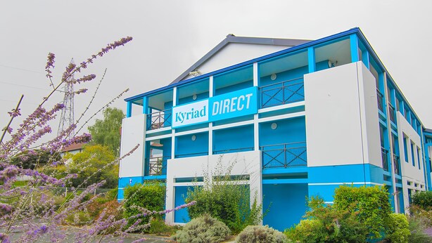 A modern building with a blue and white color scheme, featuring the sign 'Kyriad DIRECT'.