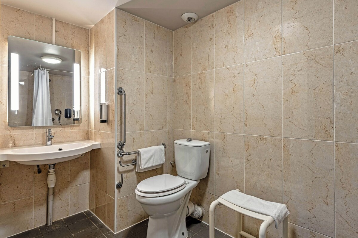 Un baño con lavamanos, inodoro y ducha.