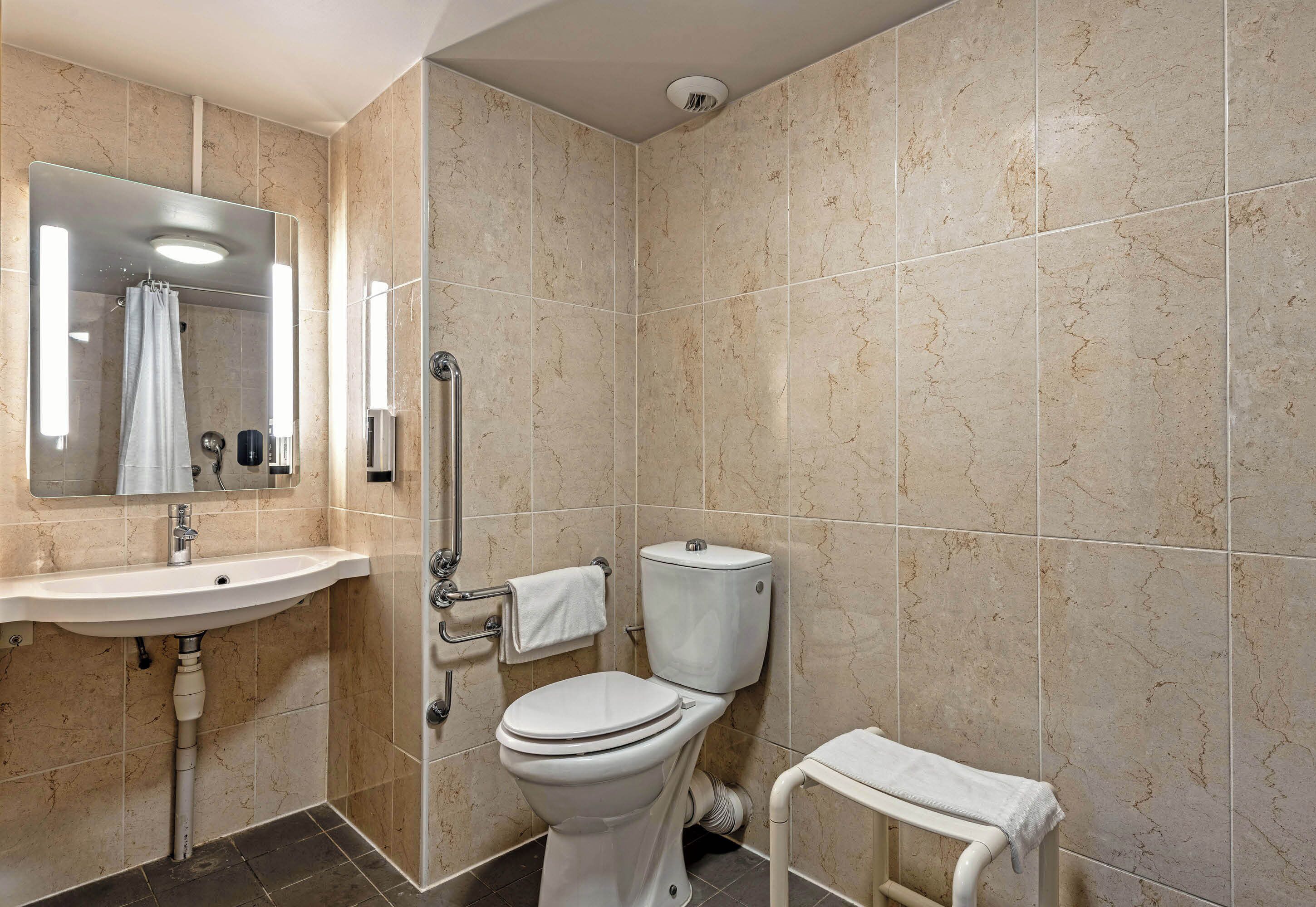 Un baño con lavamanos, inodoro y ducha.