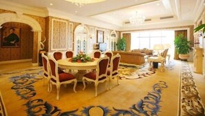 A spacious dining area with a round table and chairs, a chandelier, and a large window providing natural light. - Country Garden Phoenix Hotel Chaohu (Hefei)