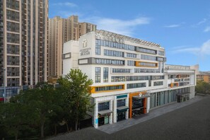 A multi-story hotel with a modern design, featuring a prominent entrance and a rooftop terrace. - Jinjiang Metropolo Hotel Langfang Wanda Plaza (Langfang)