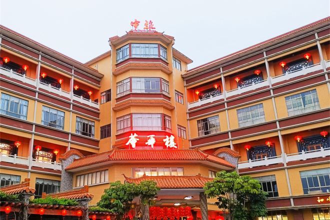 A multi-story hotel with a traditional architectural style, featuring balconies and a central entrance.