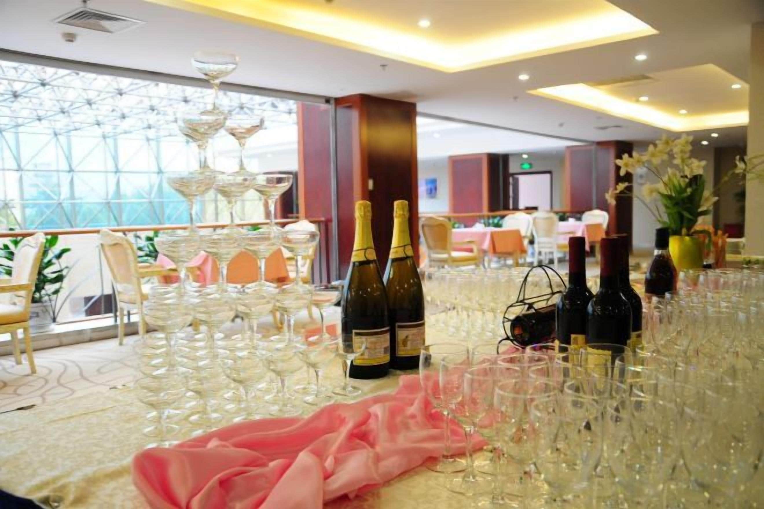 A banquet hall with tables set for a formal event, featuring champagne bottles and glasses.