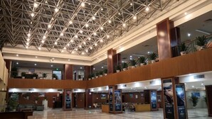 Een ruime lobby met een hoge plafond, meerdere verdiepingen en een centraal atrium.