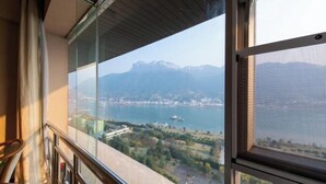 Een balkon met een helder uitzicht op een meer en bergen.