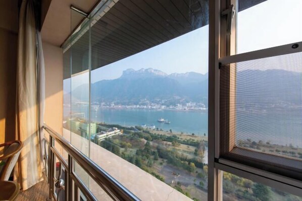 A balcony with a clear view of a lake and mountains.