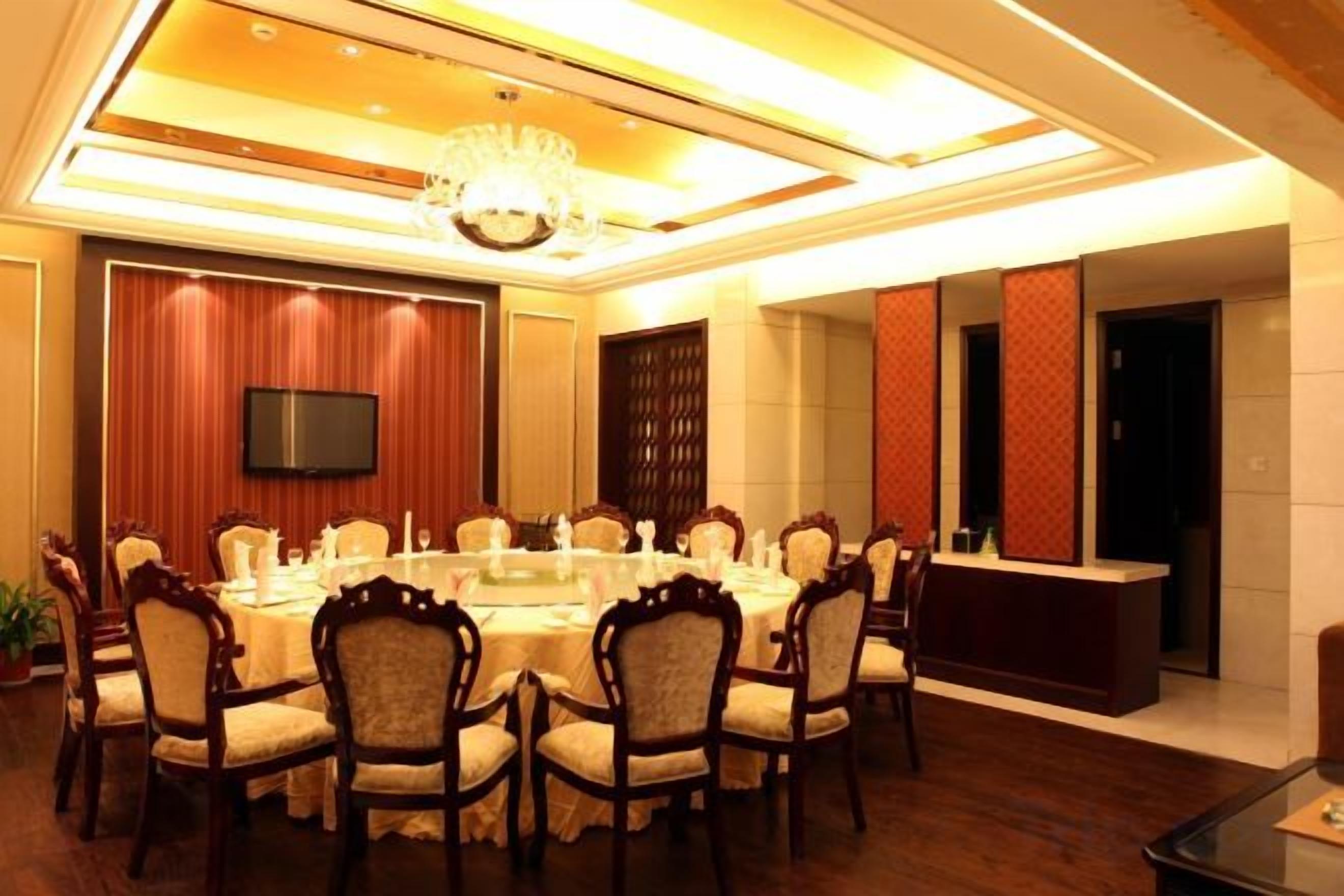 A conference room with a round table, chairs, a TV, and a reception desk.