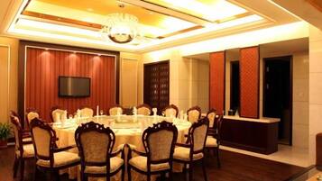A conference room with a round table, chairs, a TV, and a reception desk.