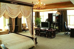 Una cama con dosel, un televisor, un escritorio y una silla en una habitación de hotel.