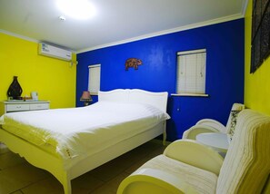 A bedroom with a bed, bedside table, lamp, and a wall-mounted decorative item. - Gulangyu Fuxing No.10 Family Inn - Xiamen (Xiamen)