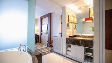 Un baño moderno con una bañera independiente, un tocador con encimera de mármol y una zona de ducha.