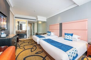 A hotel room with two beds, a desk, and a bathroom visible through an open door. - Haina Baichuan Hotel (Ningbo)