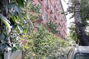 Un edificio con varias ventanas y un árbol en primer plano.