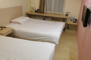 A hotel room with two single beds, a bedside table with a lamp, a small table with bottled water and a kettle, and a TV mounted on the wall. - Hejia Inn (Beijing Fuwai Hospital) (Beijing)
