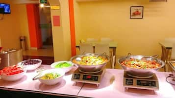 A buffet setup with various food items and a weighing scale.