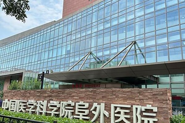 A modern building with a glass facade and a sign indicating it is a medical facility. - Hejia Inn (Beijing Fuwai Hospital) (Beijing)