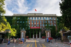 Un edificio con una bandera roja, varias ventanas y un letrero.