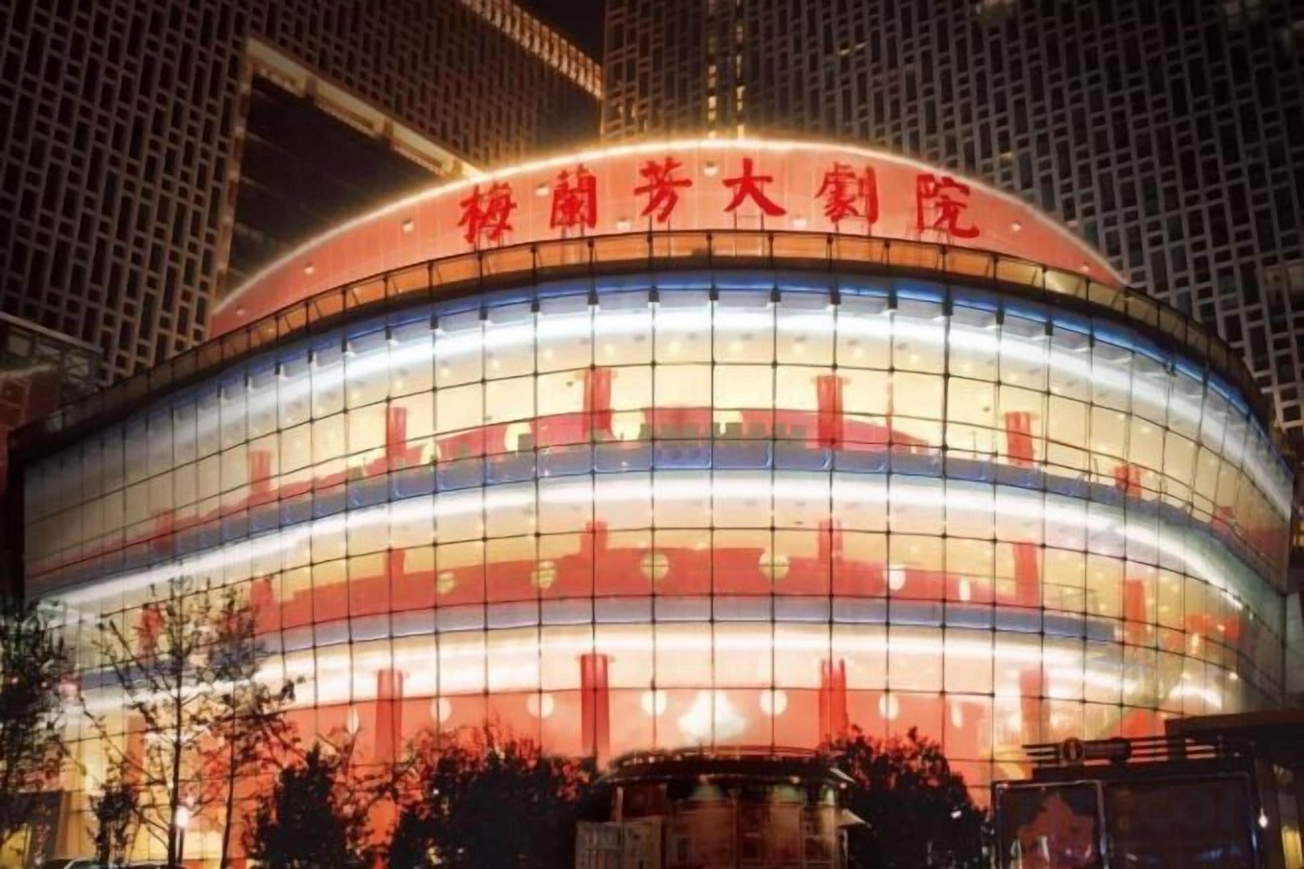 Un edificio grande y circular con una entrada destacada y señalización.