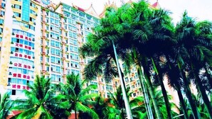 A multi-story hotel with a traditional architectural style, featuring balconies and a red roof. - Xishuangbanna Elephanthome Hotel (Xishuangbanna Dai)