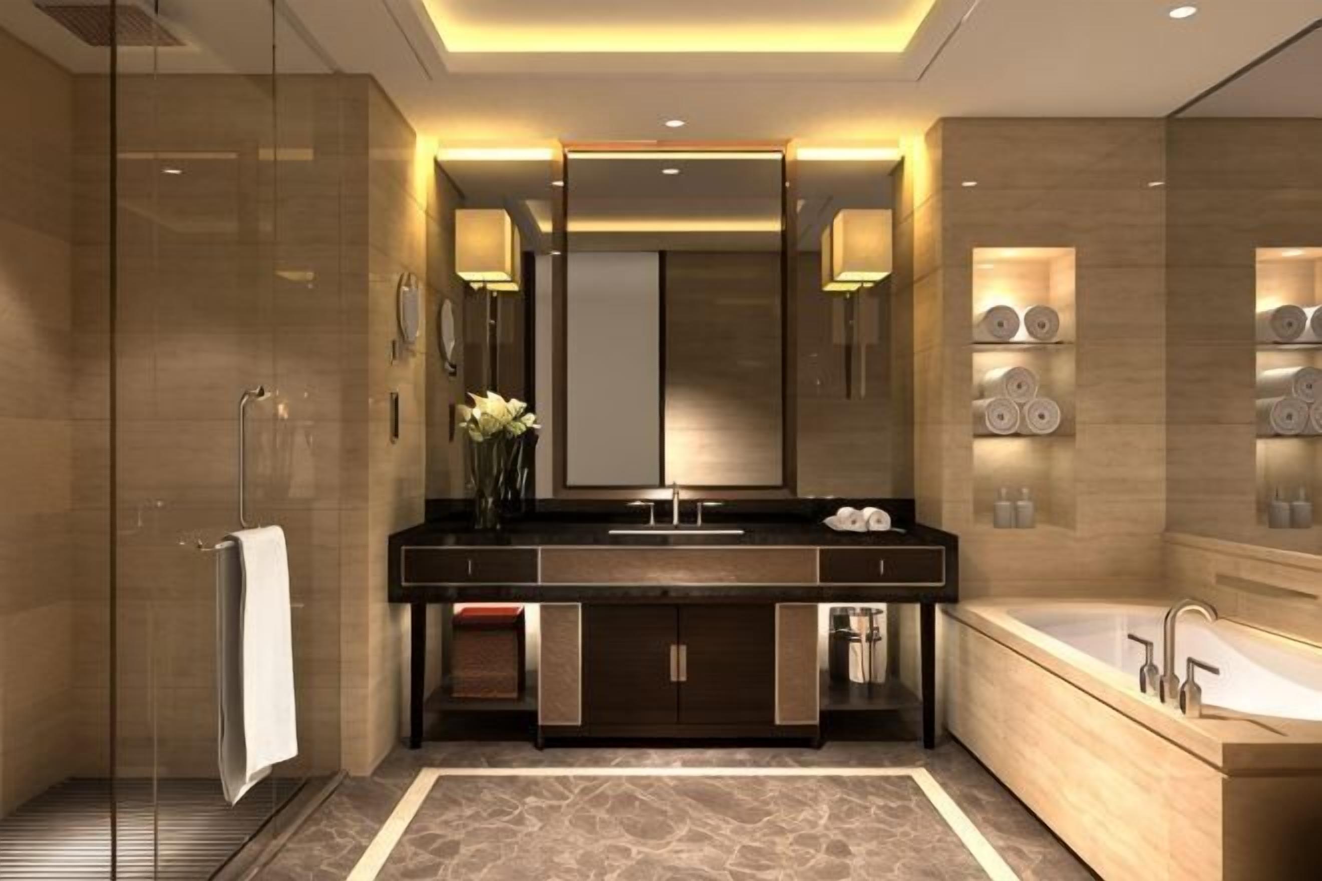 A modern bathroom with a glass shower enclosure, a large vanity with a mirror, and a bathtub.