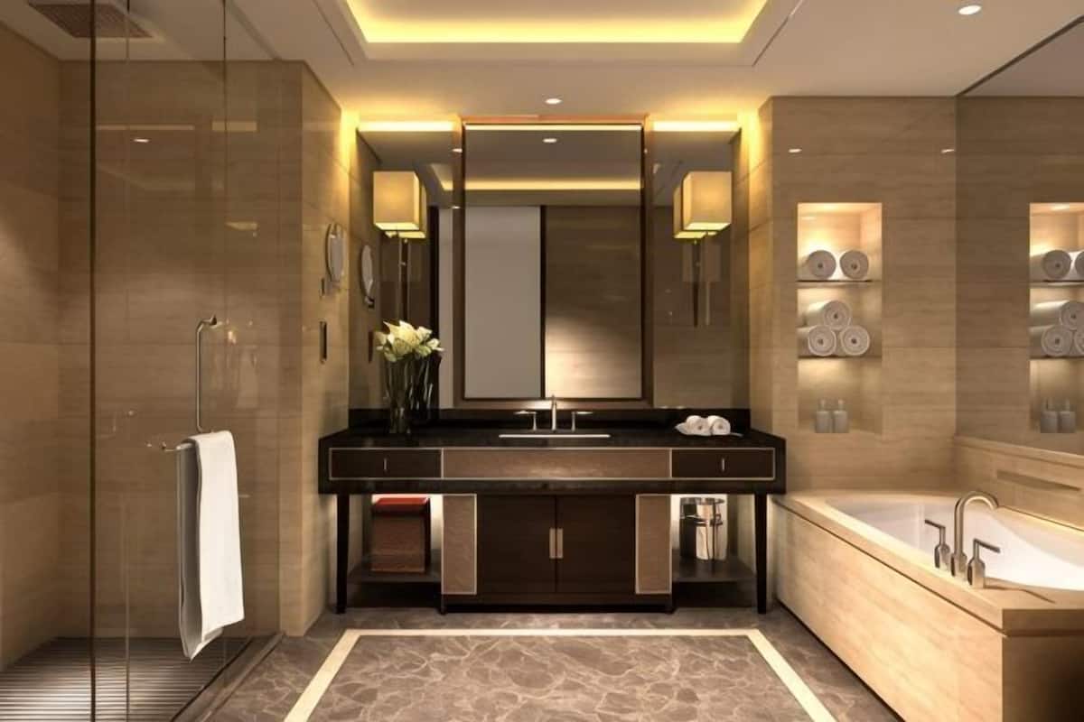 A modern bathroom with a glass shower enclosure, a large vanity with a mirror, and a bathtub.
