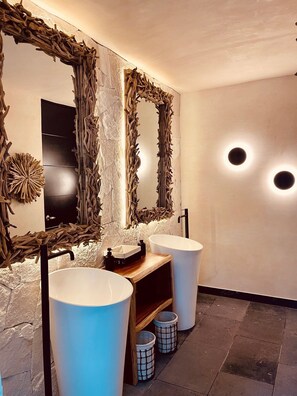 A modern bathroom with two sinks, a wooden vanity, and large mirrors with natural wood frames. - Grand City Hotel Cancun - Near Market 28 (Cancun)