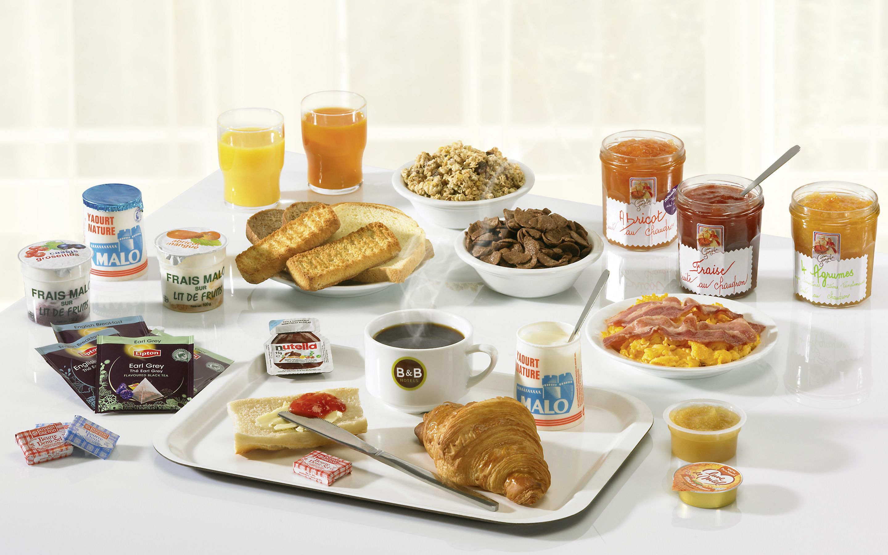 A breakfast spread with various food items and beverages.