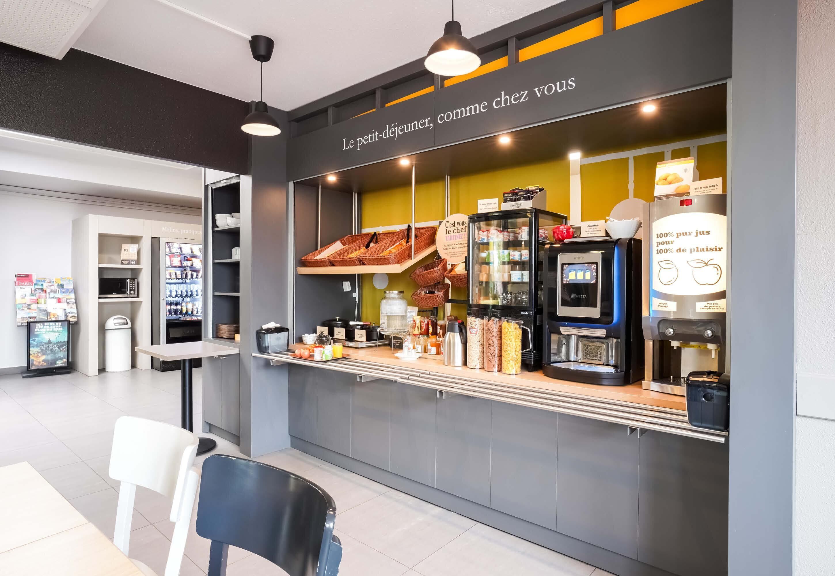 A café with a counter, shelves with products, a coffee machine, and a sign in French.