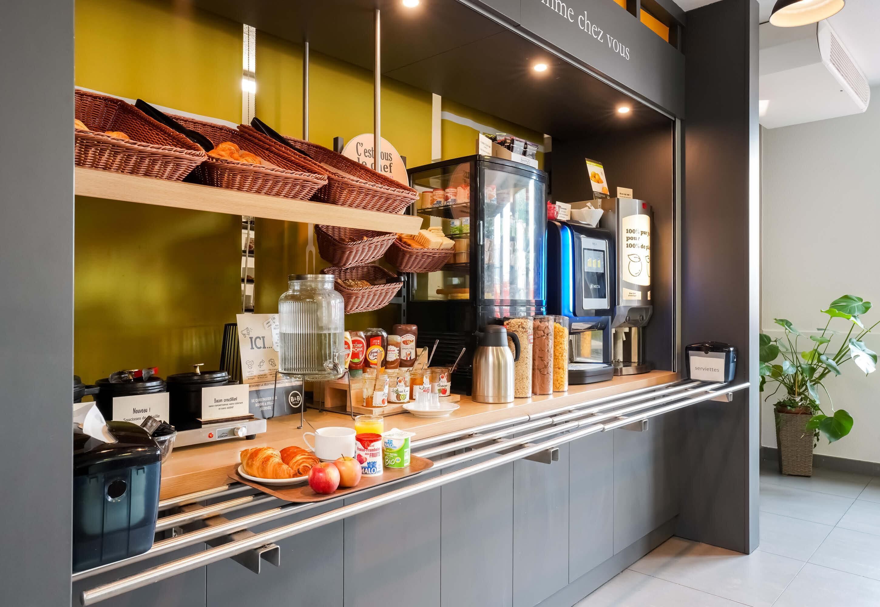 Una barra de desayuno con cestas de mimbre, una máquina de café y diversos alimentos.