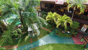 Un jardín en la azotea con palmeras, una piscina y un restaurante llamado 'Resto'.