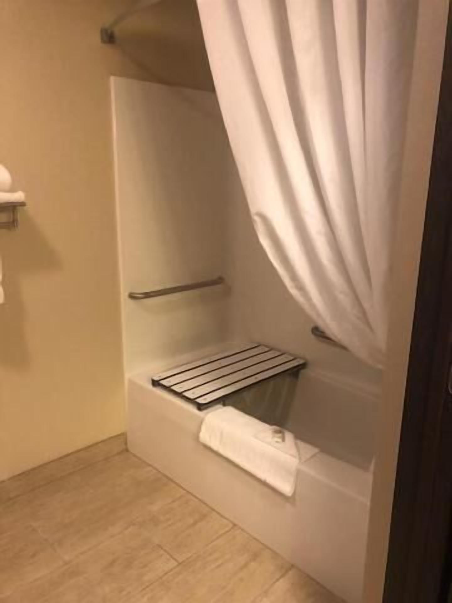 Un petit espace douche fermé, équipé d’un porte-serviettes et d’une étagère.