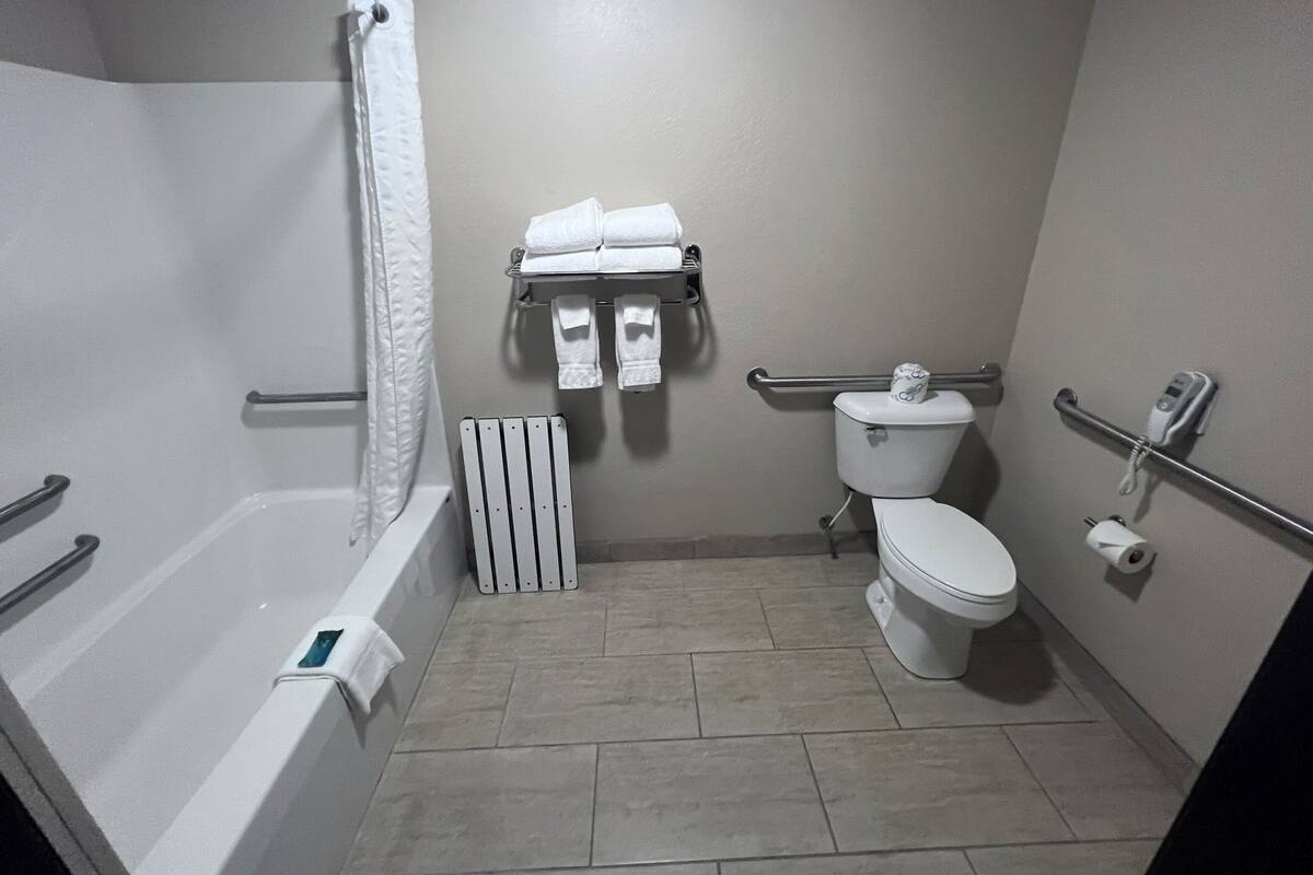 A bathroom with a bathtub, toilet, and shower.